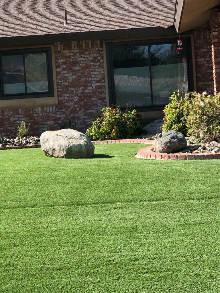 Grass in front yard with boulder