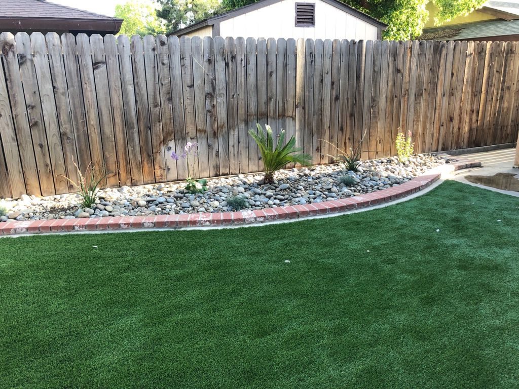 Backyard astroturf with river rock