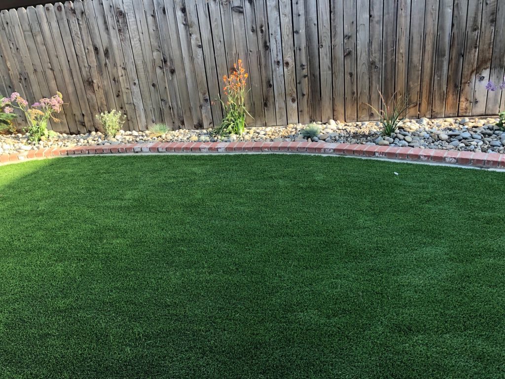 Backyard astroturf with brick trim